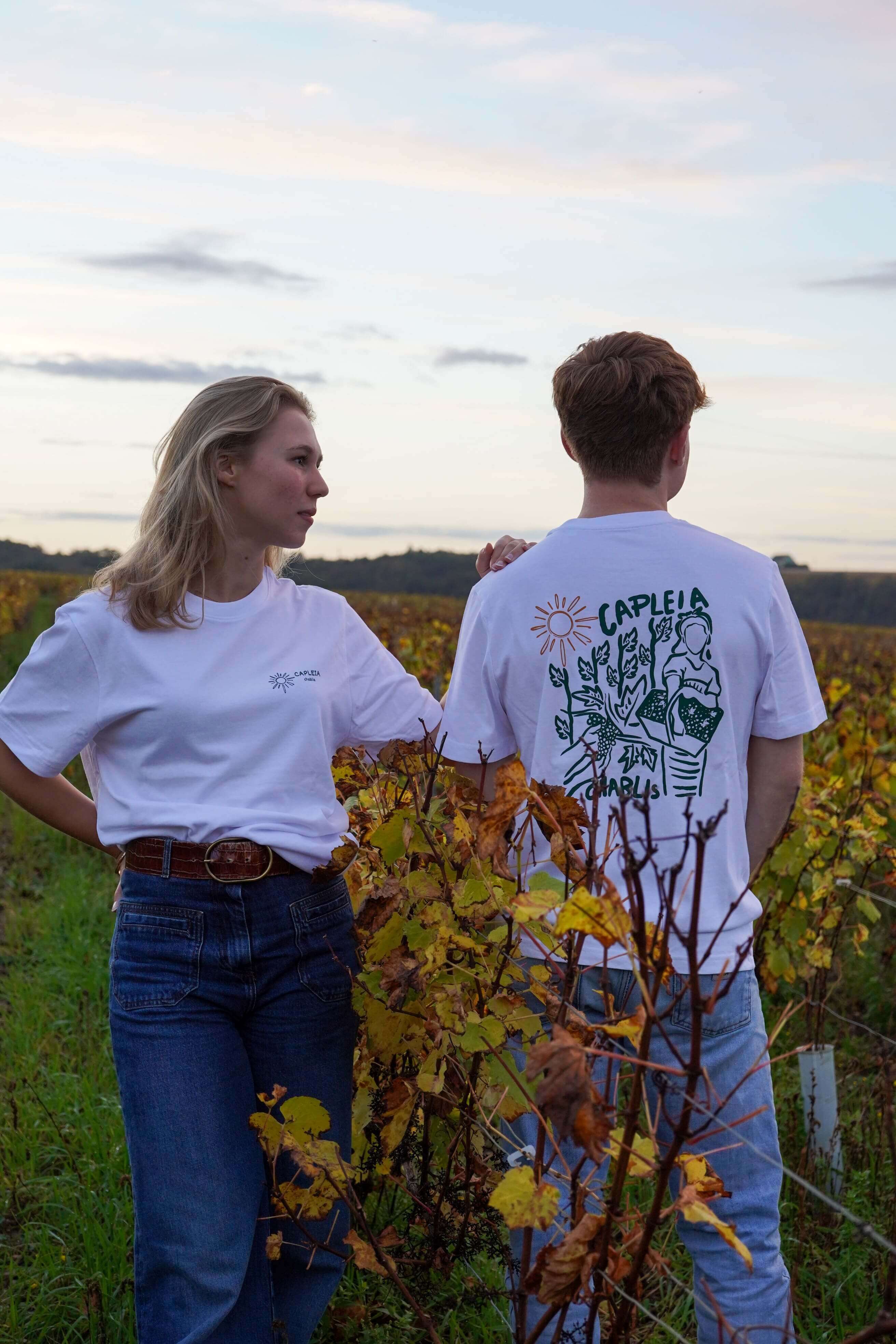 Image of Modèle en coton biologique avec dessin de vendange, couple admirant les vignes au coucher du soleil.