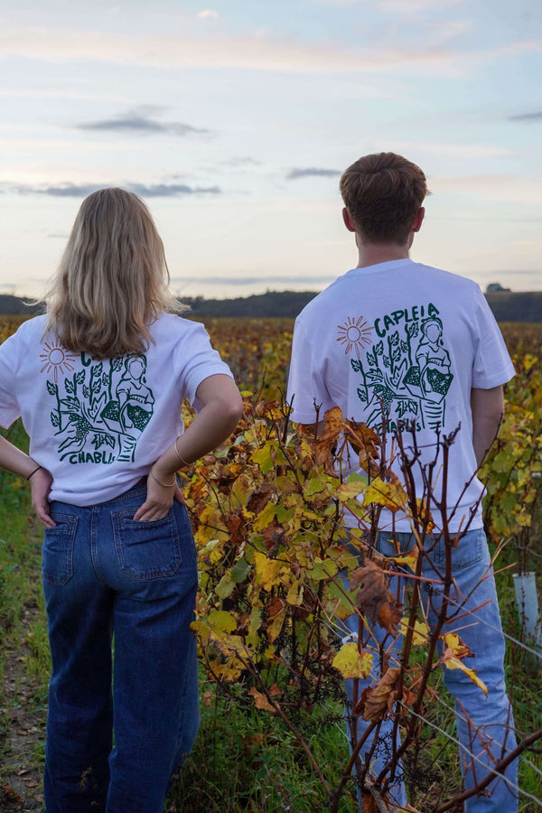 Couple wearing La Vendange t-shirts in a vineyard, showcasing a relaxed fit in organic cotton, celebrating the harvest.